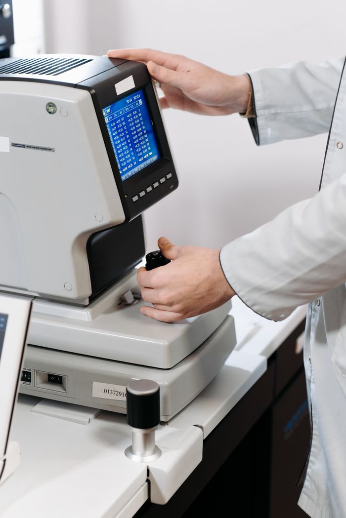 Doctor adjusts eye examination equipment for a precise diagnosis.
